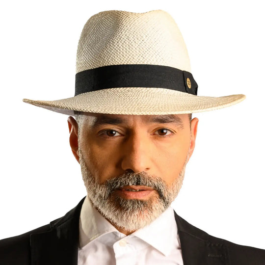 primo piano frontale di uomo con barba che indossa un cappello di panama in stile fedora color bianco fatto da cappelleria primario nesti