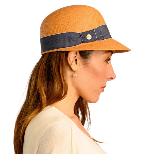 primo piano laterale di donna adulta con capelli lunghi che indossa un cappello di panama con visiera corta color avana realizzato da cappelleria primario nesti