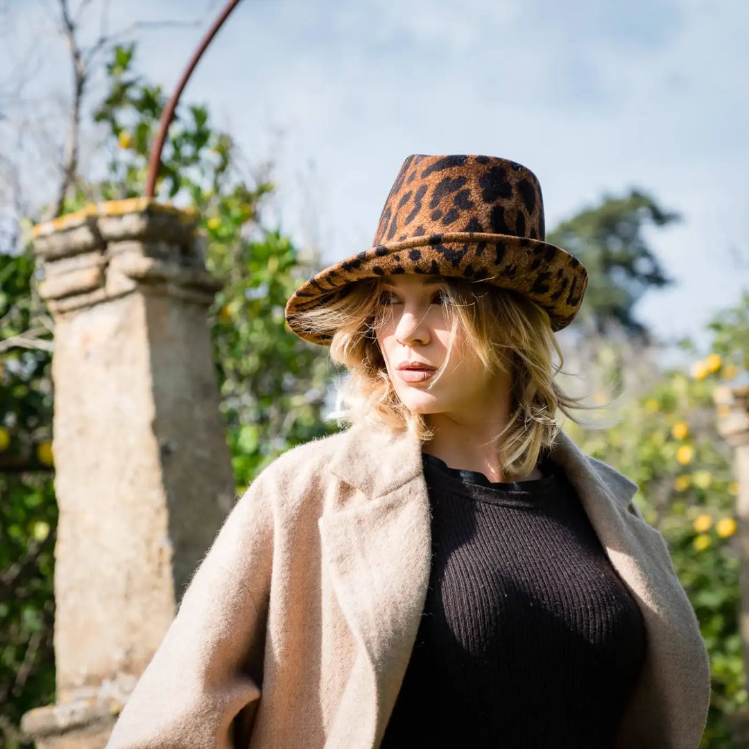 cappello a cloche asimmetrica animalier in feltro di lana merinos primario nesti modella con cappotto beige in location storica con colonne perfetto cappello donna