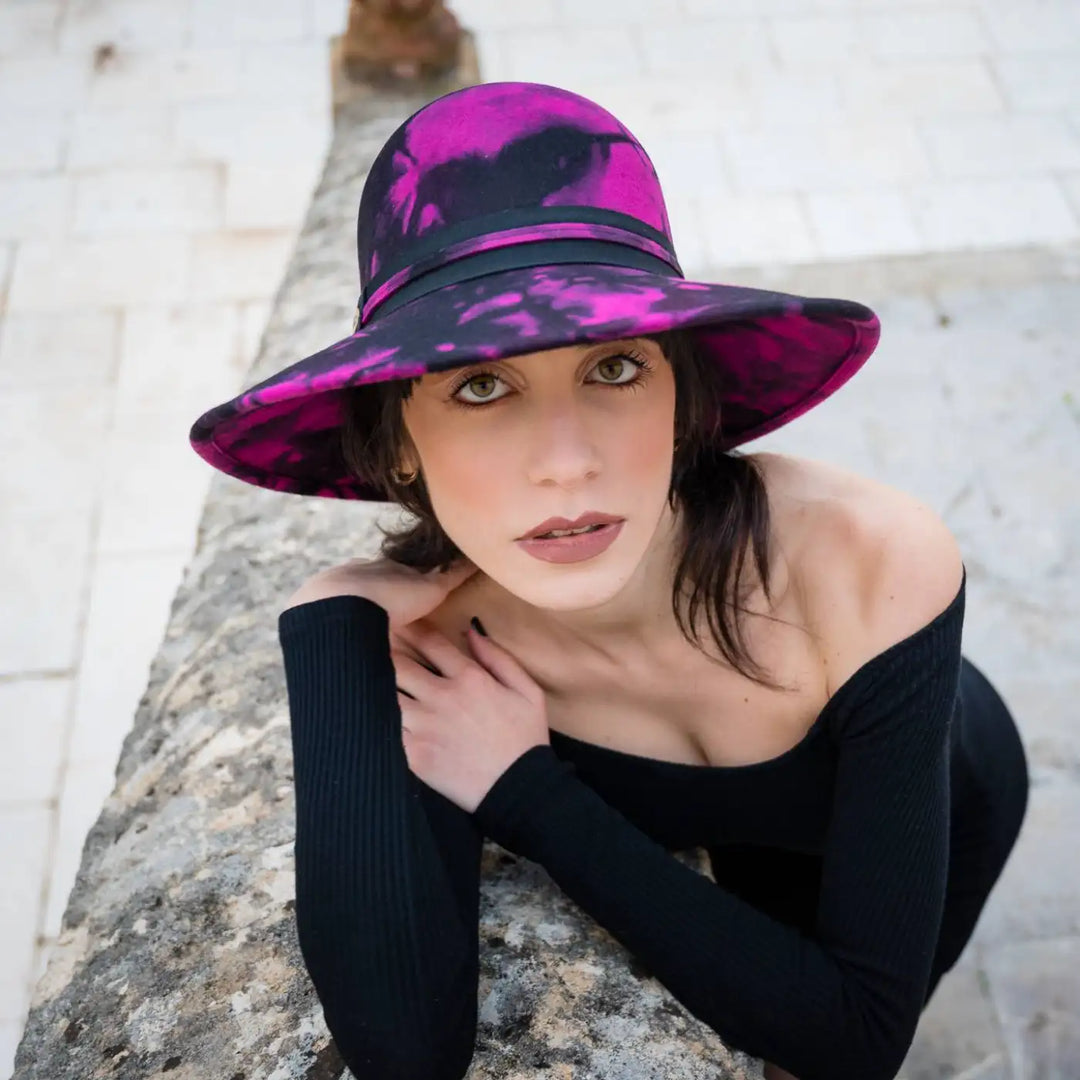 cappello a pamela a tesa larga in feltro di lana merinos maltinto primario nesti fucsia primo piano modella su sfondo architettonico stile retro contemporaneo