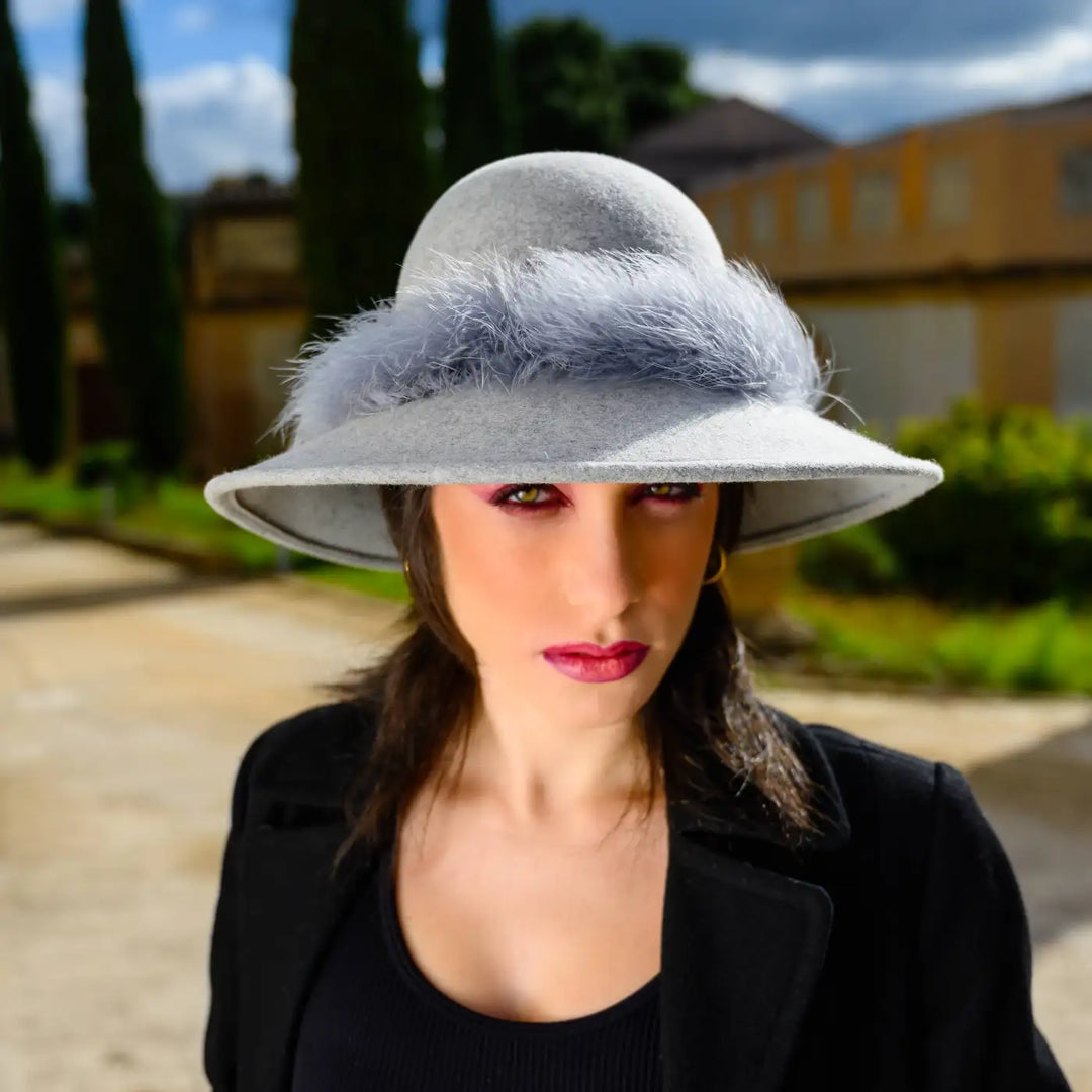 cappello a pamela in feltro di lana merinos con girotesta in marabou primario nesti grigio ritratto modella in giardino sguardo intenso