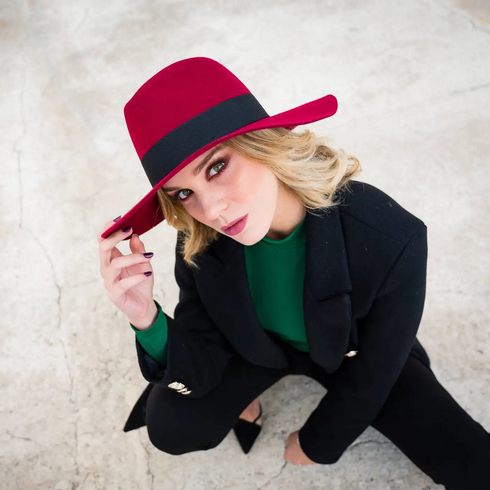 cappello con tesa a taglio vivo in feltro di lana merinos antipioggia primario nesti rosso rubino posa artistica di modella vista dallalto