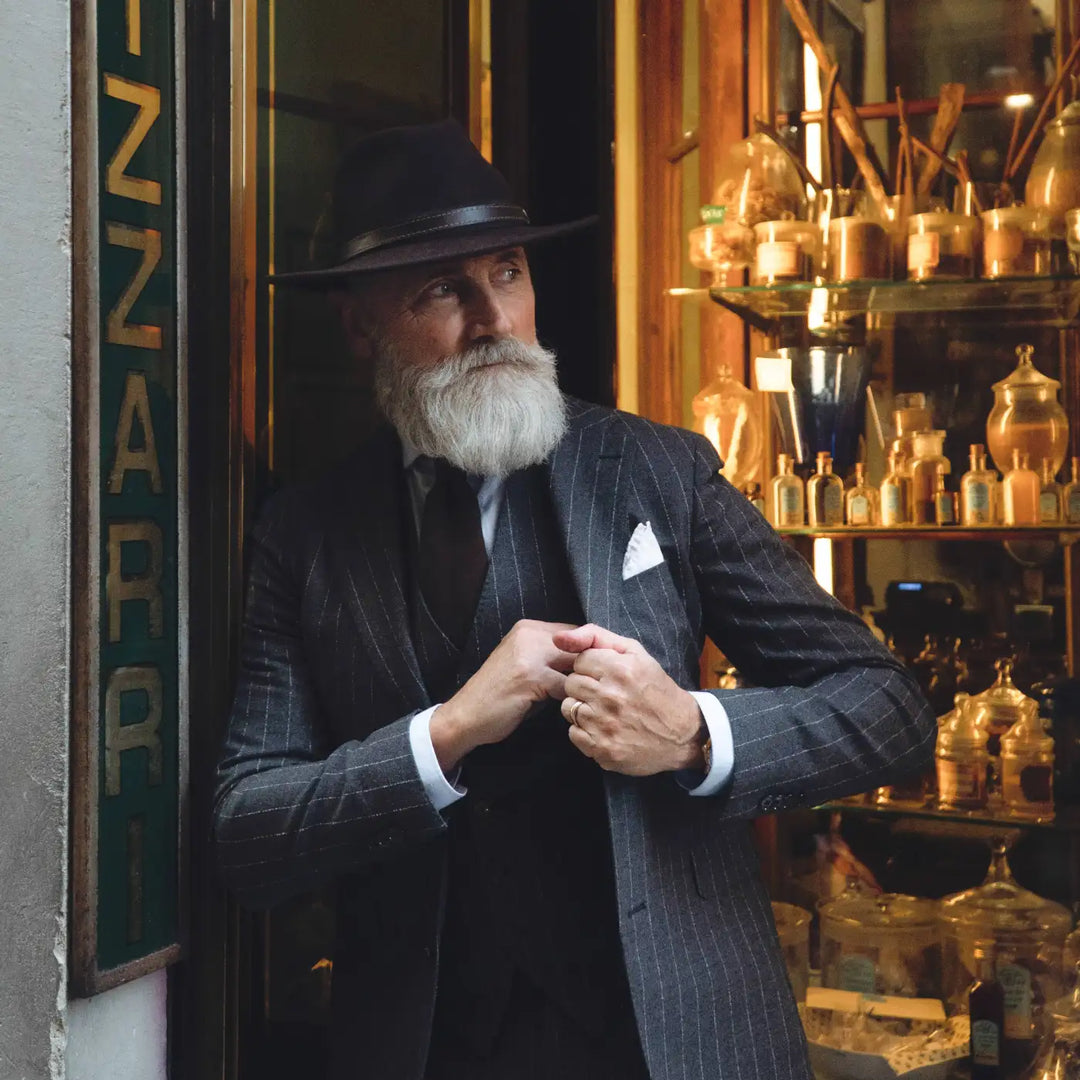 cappello fedora tradizionale primario nesti antipioggia su modello maturo nel suo stile vintage appoggiato ad un negozio fiorentino