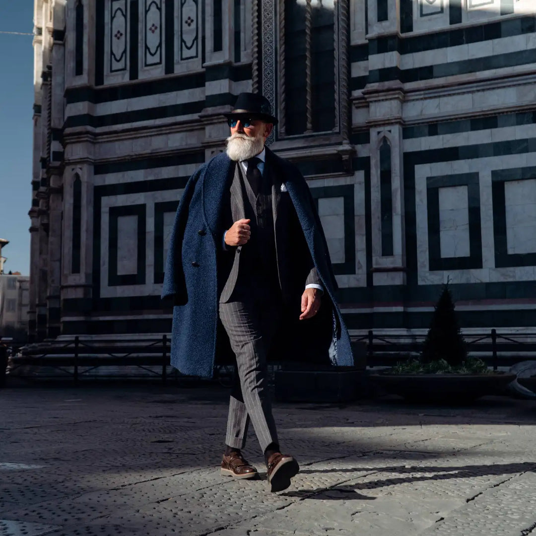 cappello trilby classico primario nesti in lana merinos colore blu su modello maturo nel suo stile italiano con sfondo del duomo di firenze