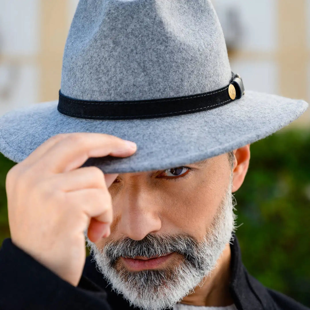 dettaglio cappello a tesa media in feltro di lana merinos primario nesti grigio primo piano intenso modello maturo maestria artigianale in evidenza