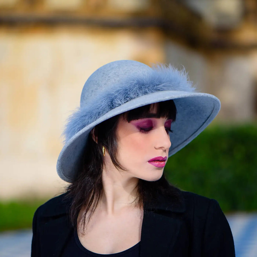dettaglio laterale della pamela primario nesti grigia marabou in primo piano profilo modella che esalta la silhouette del cappello