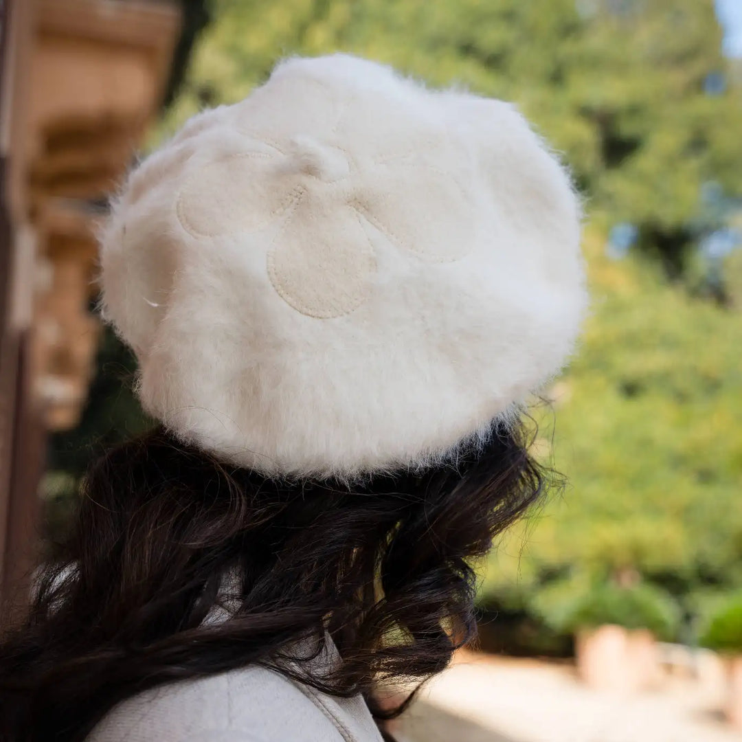 donna chic con basco parigino in angora e lapin con ricamo floreale primario nesti bianco dettaglio floreale vegetazione mediterranea sfondo