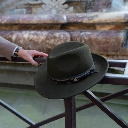 fedora tradizionale primario nesti antipioggia colore verde loden in esposizione su location storica con patina del tempo prodotto artigianale toscano