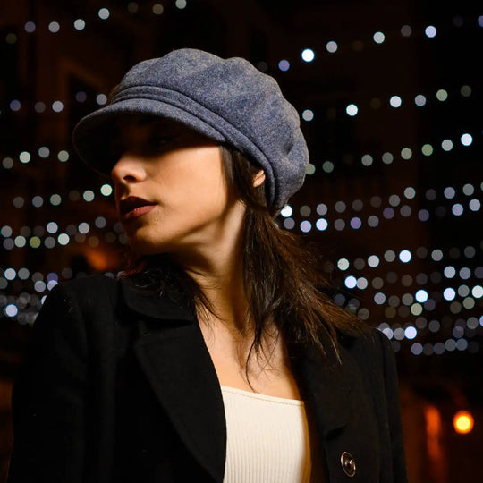 modella indossa basco con visiera e balze alla francese in lana colore carta da zucchero scatto notturno con bokeh luminoso massima funzionalita invernale