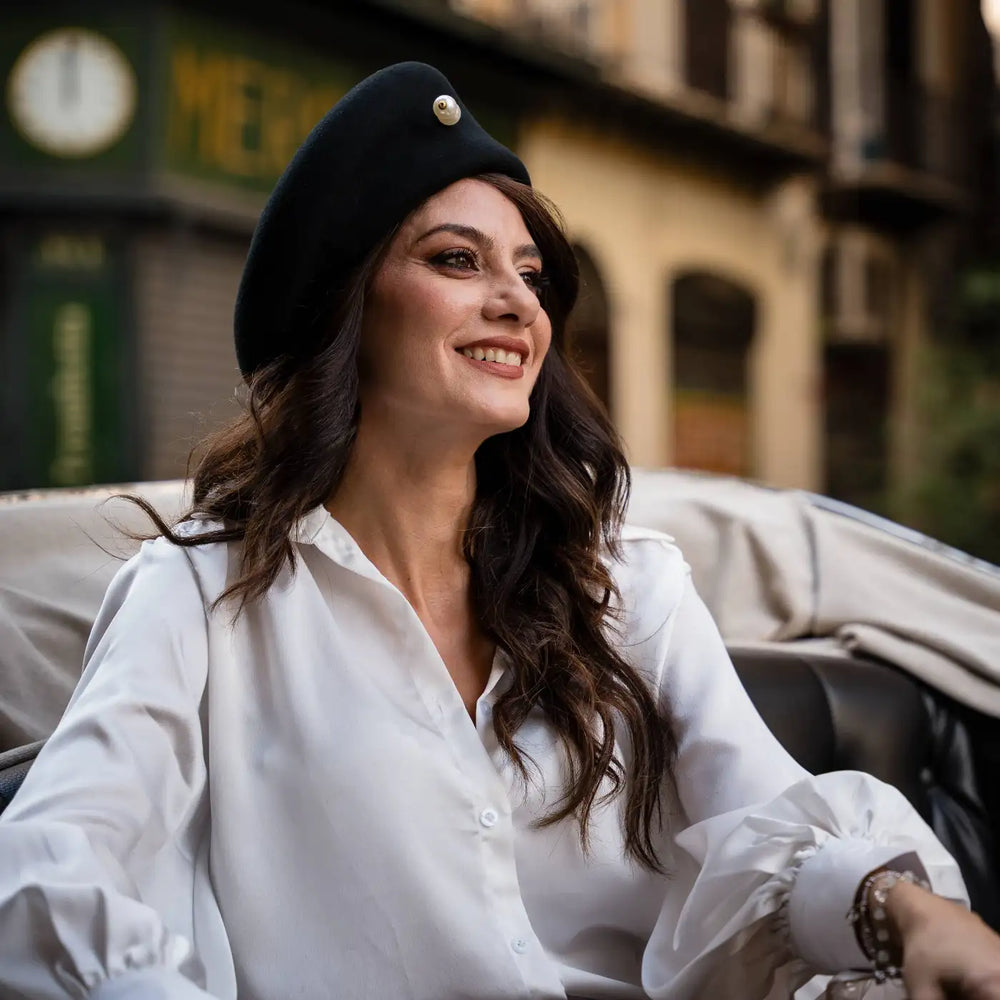 modella raffinata con basco primario nesti nero impreziosito da spilla perla look casual chic atmosfera vintage