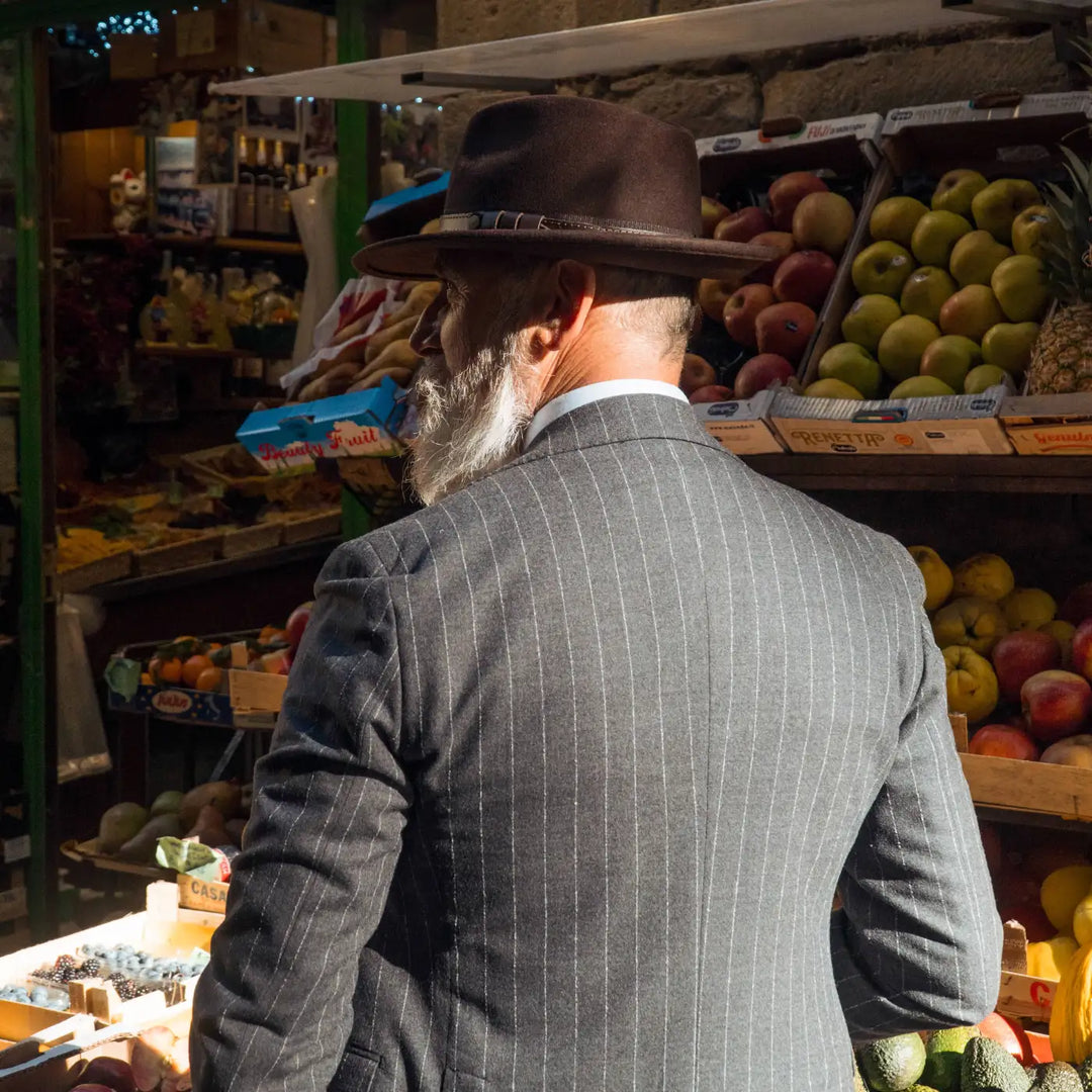 modello distinto con cappello fedora tradizionale primario nesti antipioggia colore marrone in un look classico al mercato