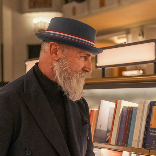 modello maturo con barba bianca e cappello pork pie primario nesti colore carta da zucchero in un momento culturale in libreria storica fiorentina