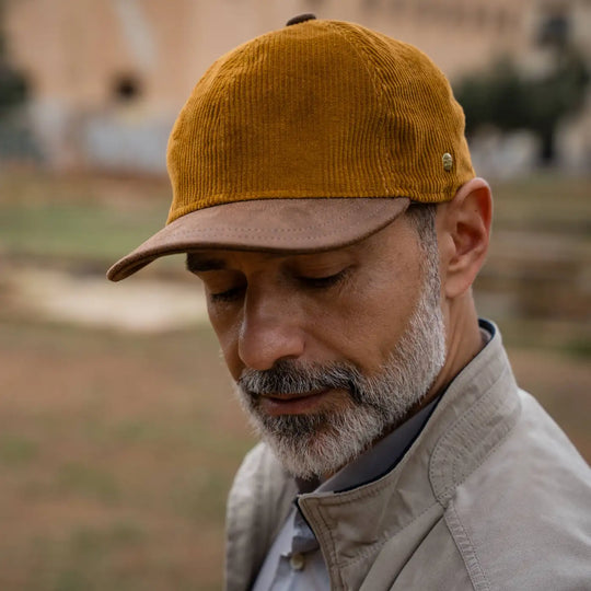 modello maturo con berretto primario nesti velluto ocra dettaglio barba curata architettura siciliana