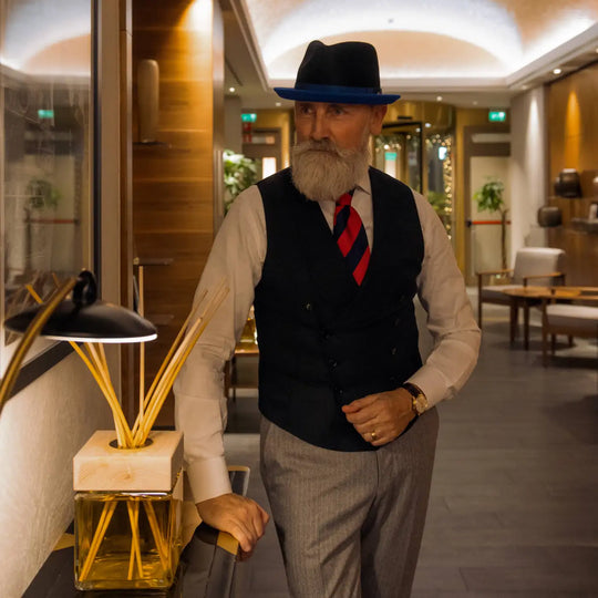 modello maturo con cappello trilby michael jackson primario nesti bicolore outfit formale con cravatta rossa in una location lussuosa di un hotel fiorentino