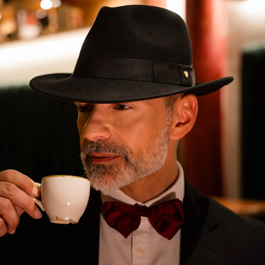 modello maturo con fedora primario nesti cashmere nero degustazione espresso illuminazione calda bar vintage