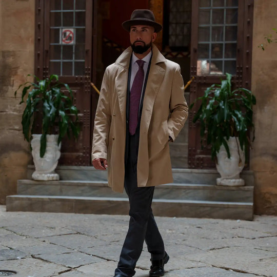 modello raffinato con cappello lobbia homburg primario nesti lapin outfit casual chic cappotto beige su total black con cravatta bordeaux