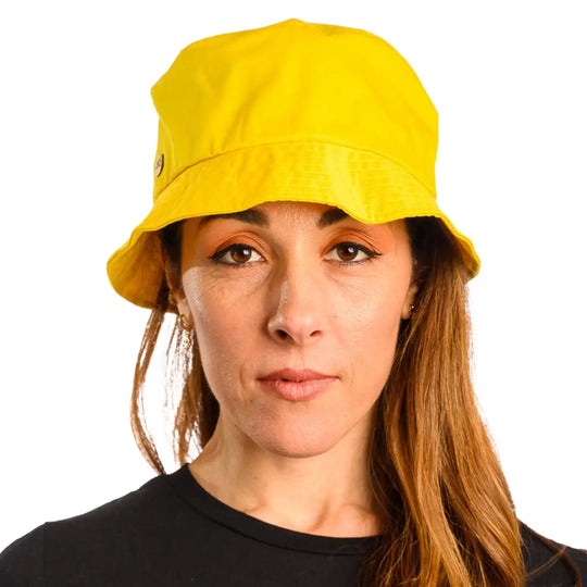 primo piano frontale di donna con capelli lunghi che indossa un cappello da pescatore sartoriale estivo color giallo realizzato da cappelleria primario nesti
