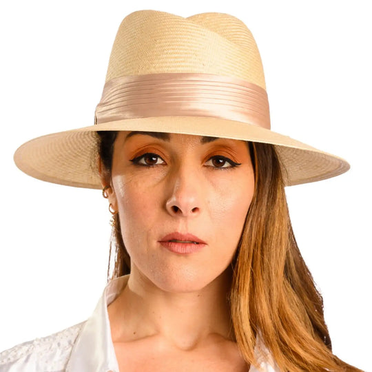 primo piano frontale di donna con capelli lunghi che indossa un cappello tesa larga elegante in parasisol color beige fatto da cappelleria primario nesti