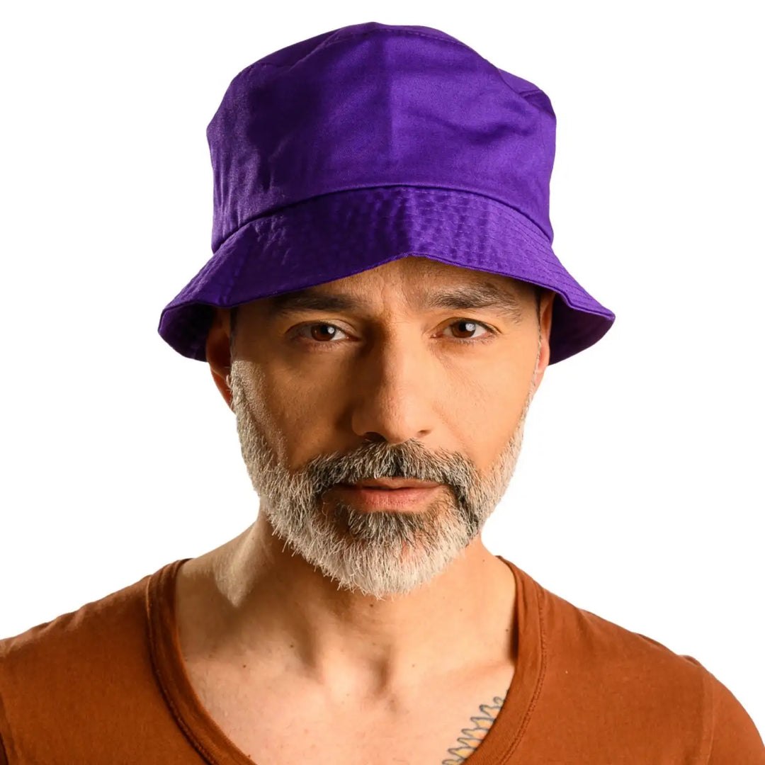 primo piano frontale di uomo con barba che indossa un cappello da pescatore sartoriale estivo color viola fatto da cappelleria primario nesti