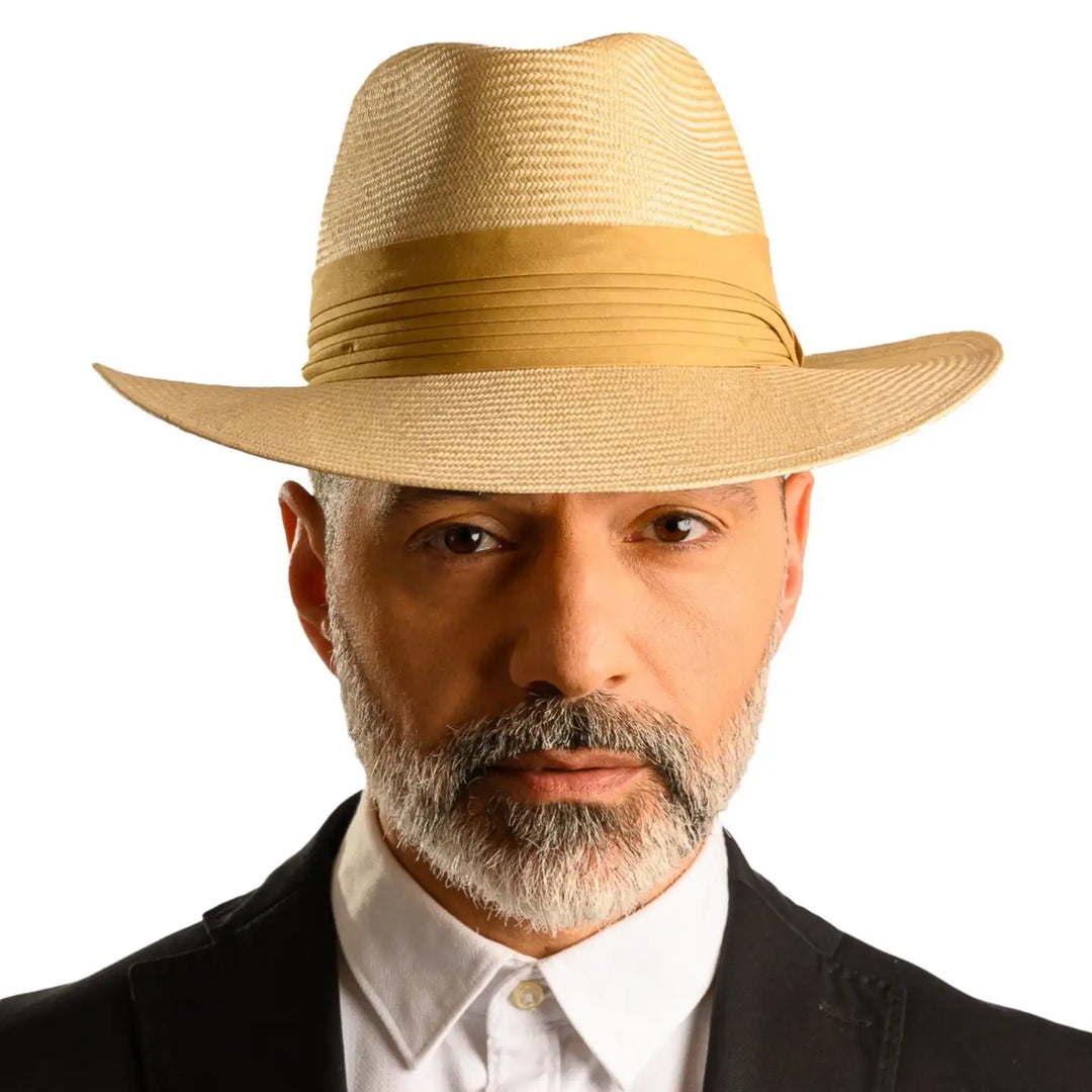 primo piano frontale di uomo con barba che indossa un cappello fedora elegante in parasisol color camel fatto da cappelleria primario nesti