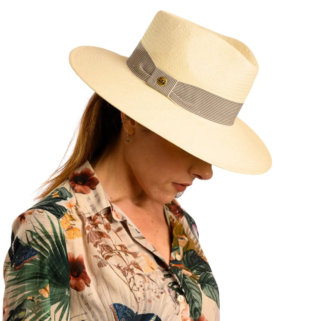 primo piano frontale inclinato di donna con capelli lunghi che indossa un cappello fedora estivo a tesa larga color naturale fatto da cappelleria primario nesti