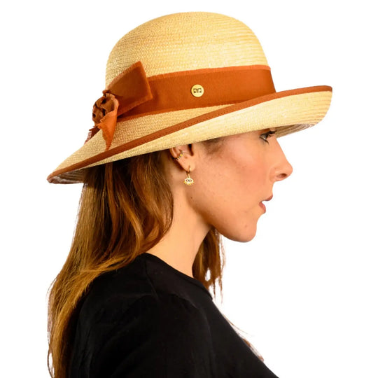 primo piano laterale di donna adulta con capelli lunghi che indossa un cappello con fiocco in paglia di firenze color treccia chiara realizzato da primario nesti