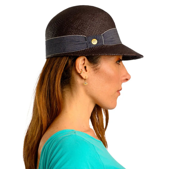 primo piano laterale di donna adulta con capelli lunghi che indossa un cappello di panama con visiera corta color nero realizzato da cappelleria primario nesti