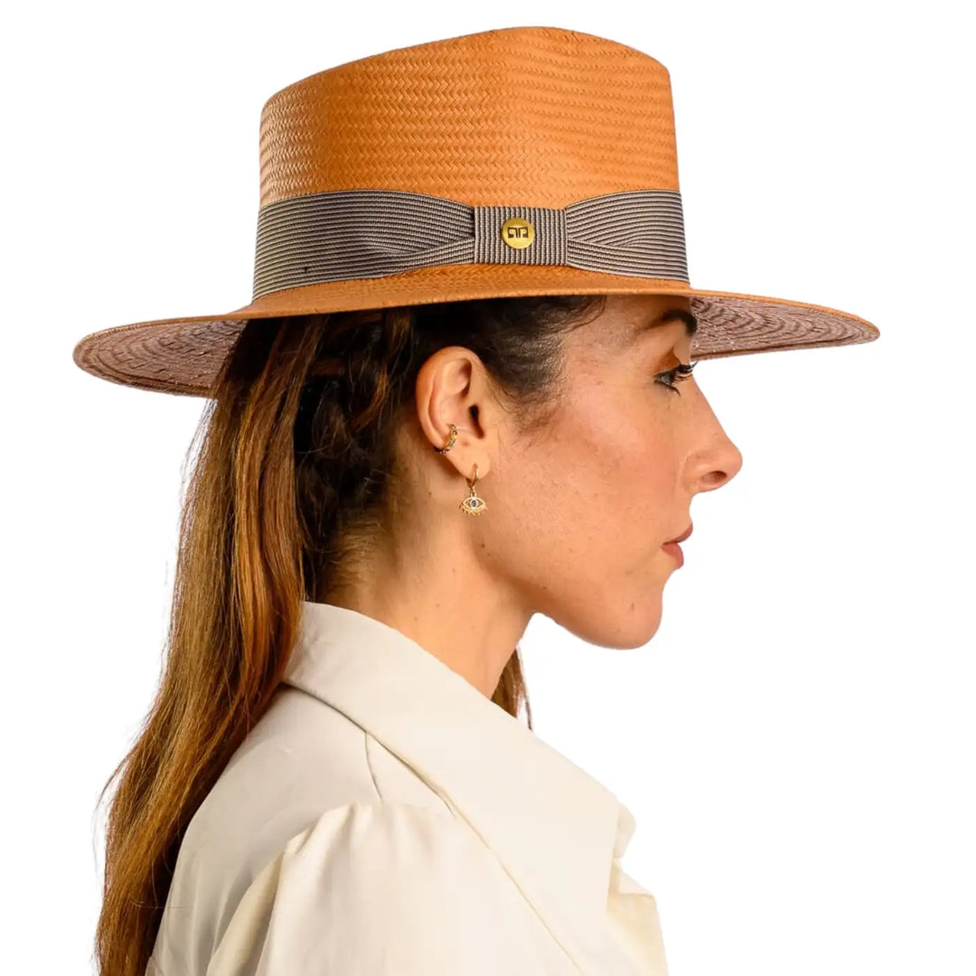 primo piano laterale di donna adulta con capelli lunghi che indossa un cappello fedora estivo a tesa larga color avana realizzato da cappelleria primario nesti