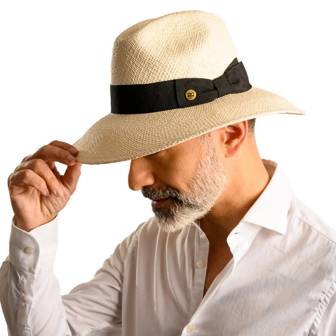 primo piano laterale inclinato di uomo con barba che indossa un cappello di panama a tesa larga da sole color bianco realizzato da cappelleria primario nesti