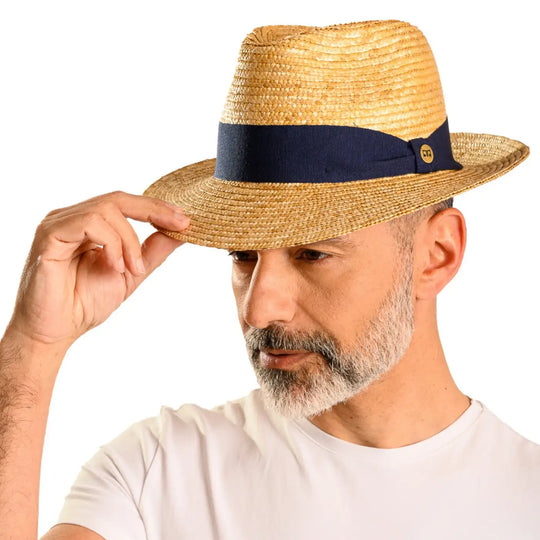 primo piano laterale inclinato di uomo con barba che indossa un cappello fedora in paglia di firenze color treccia scura realizzato da cappelleria primario nesti