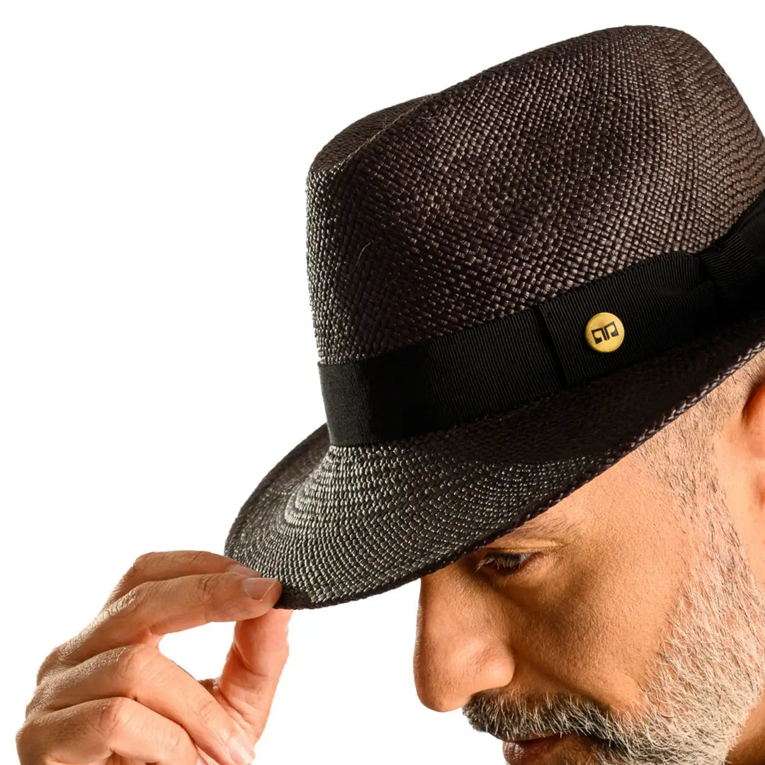 primo piano laterale ravvicinato di uomo con barba che indossa un cappello di panama in stile fedora color nero realizzato da cappelleria primario nesti