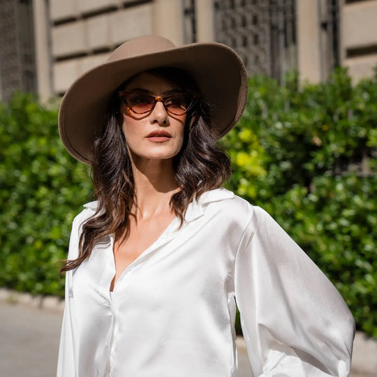 street style con cappello canotto primario nesti tesa larga blusa bianca fluida dettagli architettonici classici