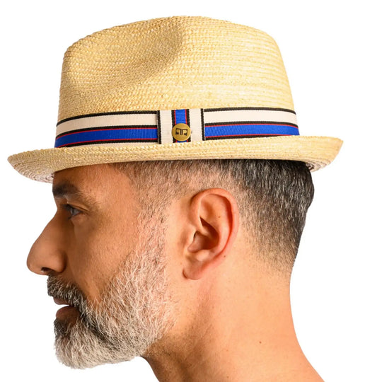 vista laterale di un uomo con barba che indossa un cappello da mare in paglia di firenze color treccia chiara fatto a mano da cappelleria primario nesti