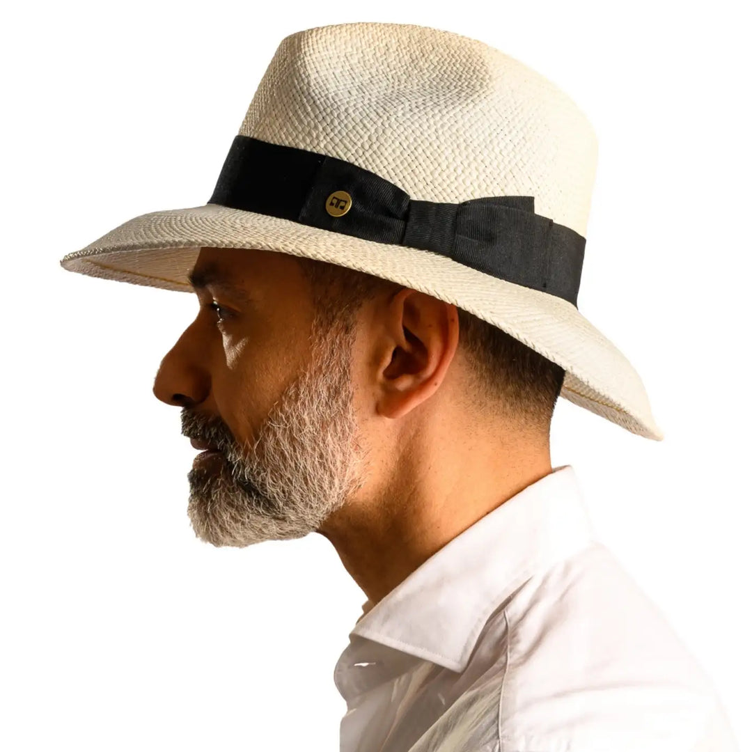 vista laterale di un uomo con barba che indossa un cappello di panama a tesa larga da sole color bianco fatto a mano da cappelleria primario nesti