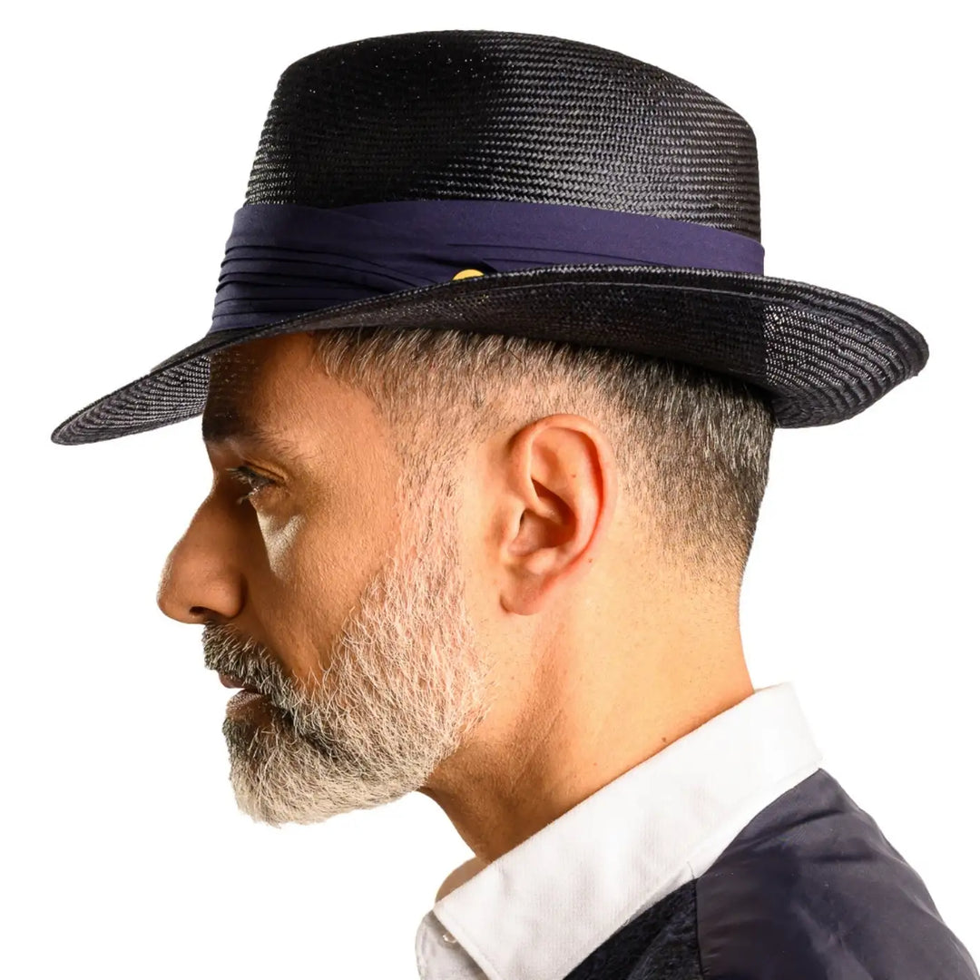 vista laterale di un uomo con barba che indossa un cappello fedora elegante in parasisol color blu fatto a mano da cappelleria primario nesti