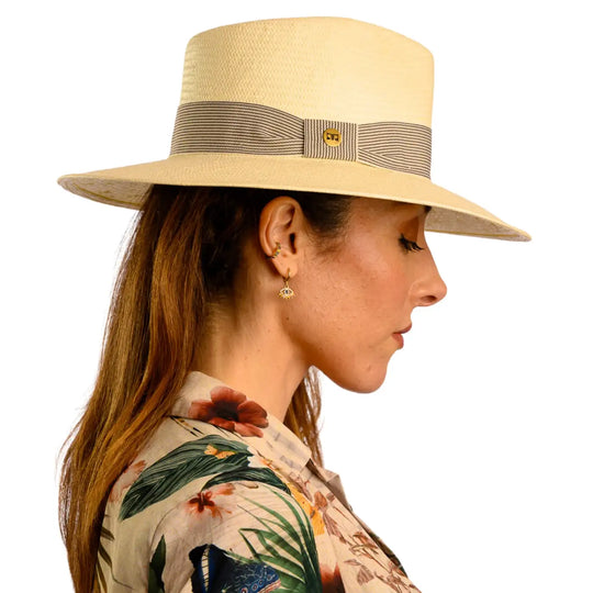 vista laterale di una donna con capelli lunghi che indossa un cappello fedora estivo a tesa larga color naturale fatto a mano da cappelleria primario nesti