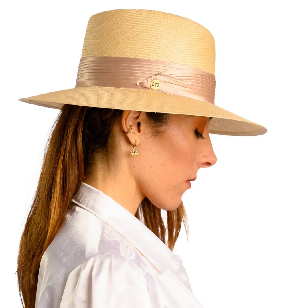 vista laterale di una donna con capelli lunghi che indossa un cappello tesa larga elegante in parasisol color beige fatto a mano da cappelleria primario nesti