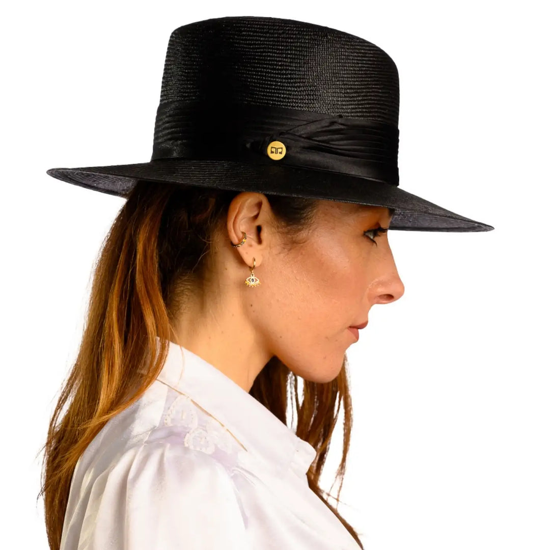 vista laterale di una donna con capelli lunghi che indossa un cappello tesa larga elegante in parasisol color nero fatto a mano da cappelleria primario nesti