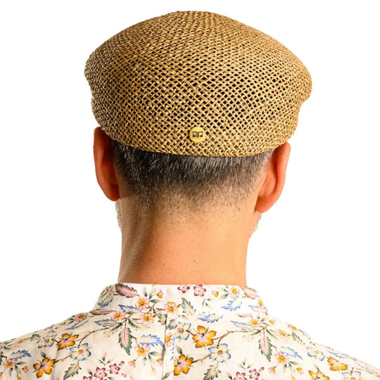 vista posteriore di un uomo con barba che indossa un coppola siciliana estiva di paglia color grezzo fatto a mano da cappelleria primario nesti