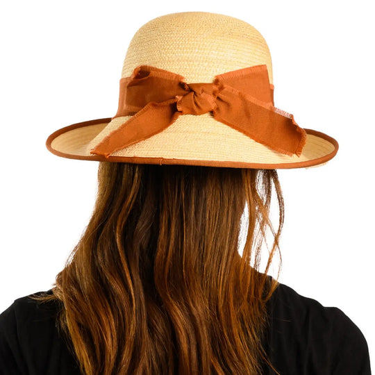 vista posteriore di una donna con capelli lunghi che indossa un cappello con fiocco in paglia di firenze color treccia chiara fatto a mano da primario nesti